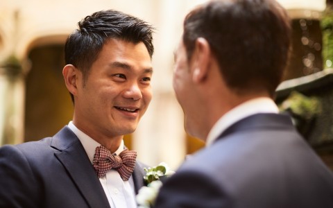 a man in a suit and bow tie smiling