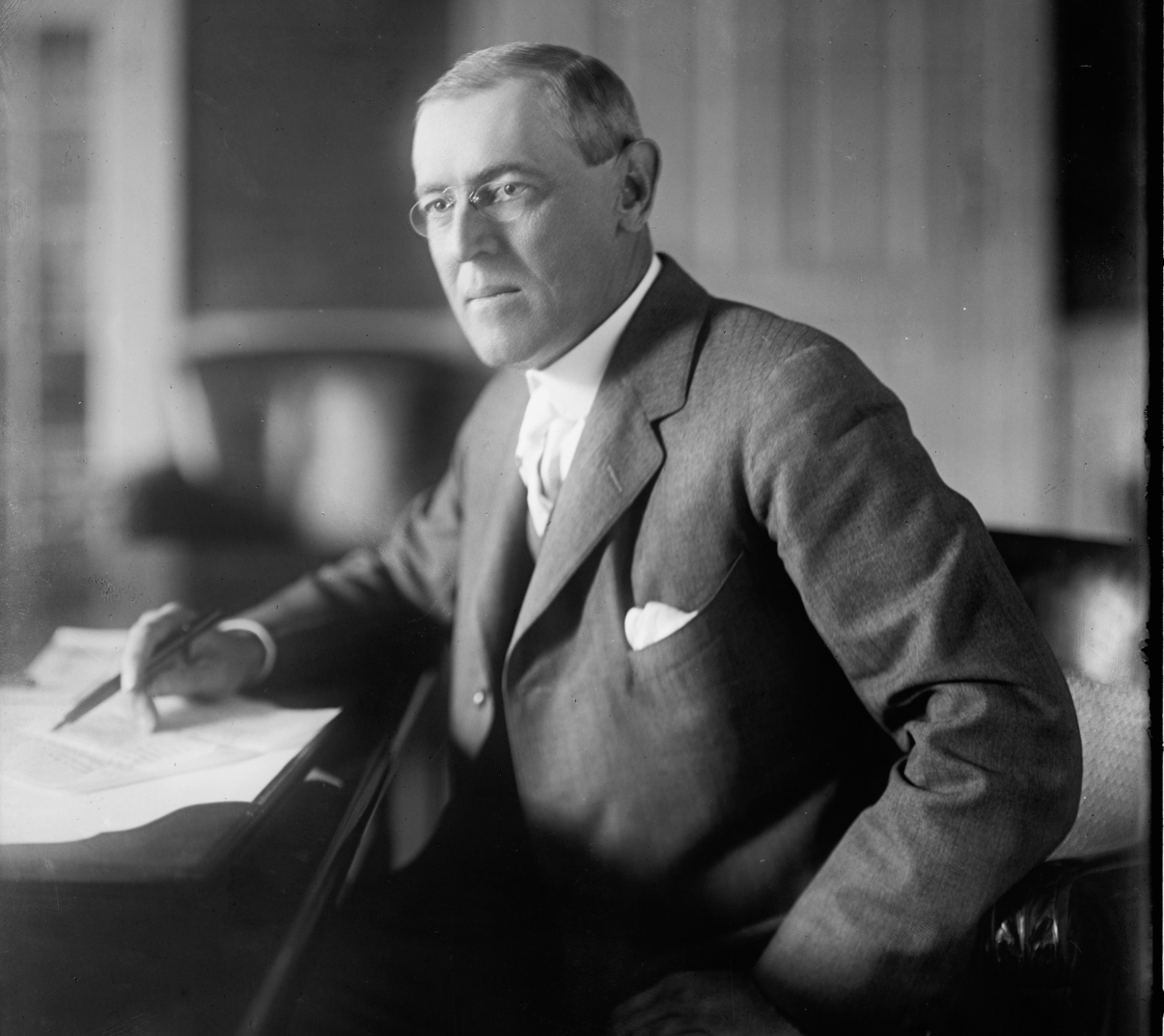 a man sitting at a desk with a pen and paper