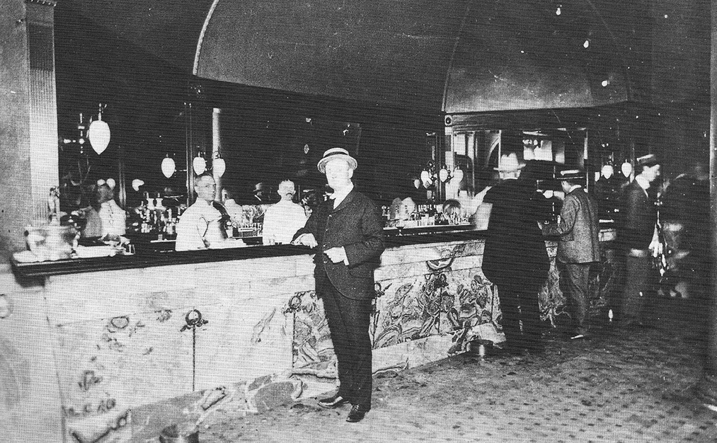 a group of men standing at a bar