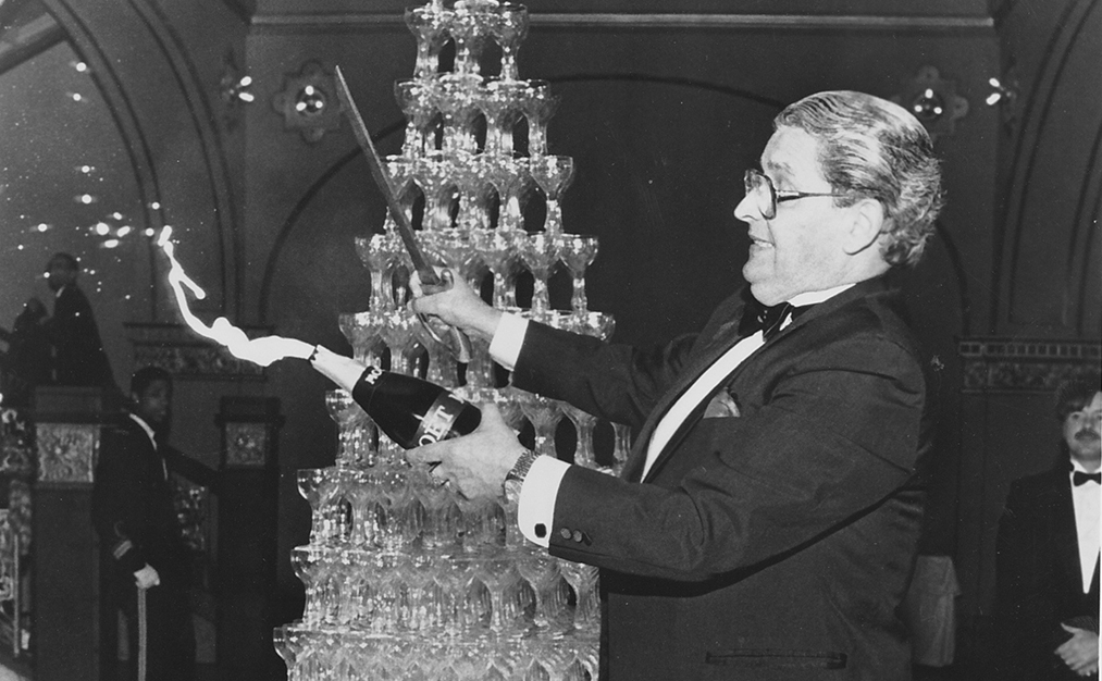 a man holding a bottle and a bottle of champagne
