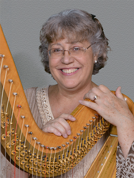 a woman smiling with a harp