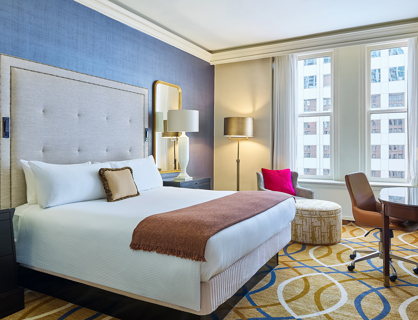 a hotel room with a bed and chairs