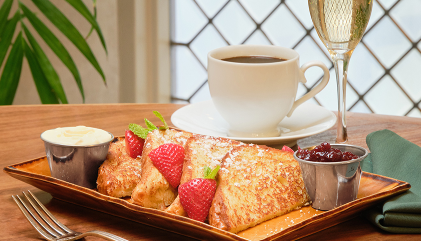 a plate of french toast with strawberries and jam
