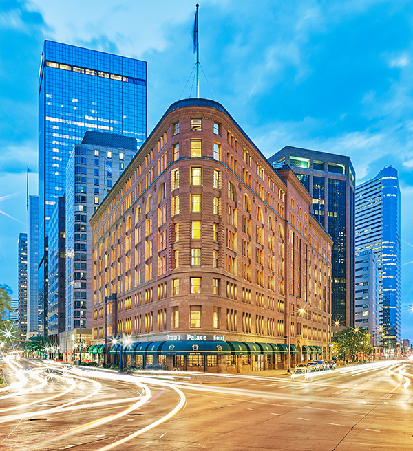 Brown Palace Hotel street with a large building and a street with cars and buildings