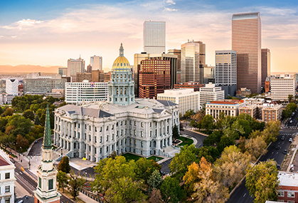 a large white building with a dome on the top and a city skyline