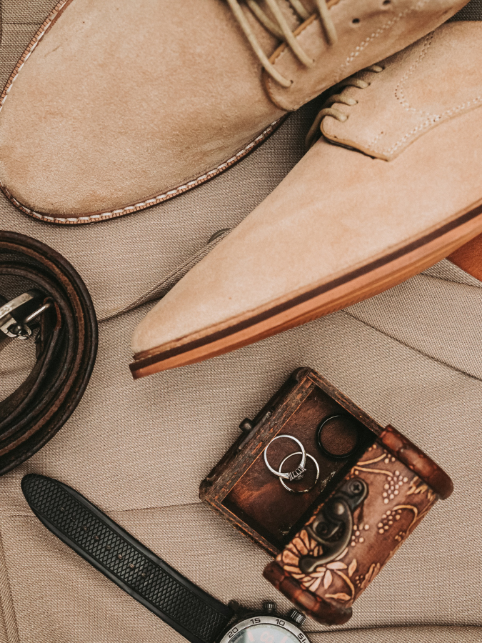 a belt and shoes next to a box of rings