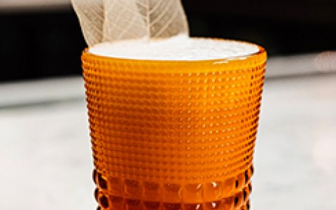 signature cocktail served in an amber shot glass