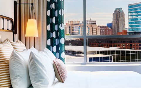 a bed with a window and a city view