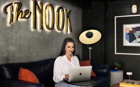 a woman sitting on a couch using a laptop