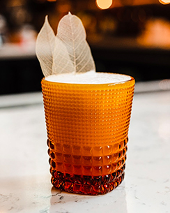 signature cocktail served in an amber shot glass