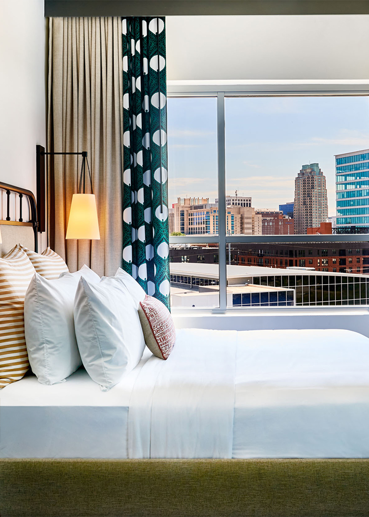 a bed with a window and a city view