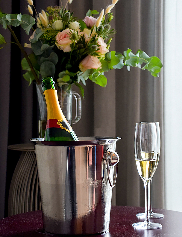 a champagne bottle in a bucket and a glass of champagne