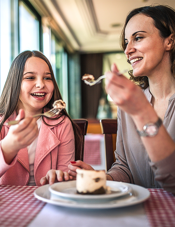 a woman and a girl eating dessert