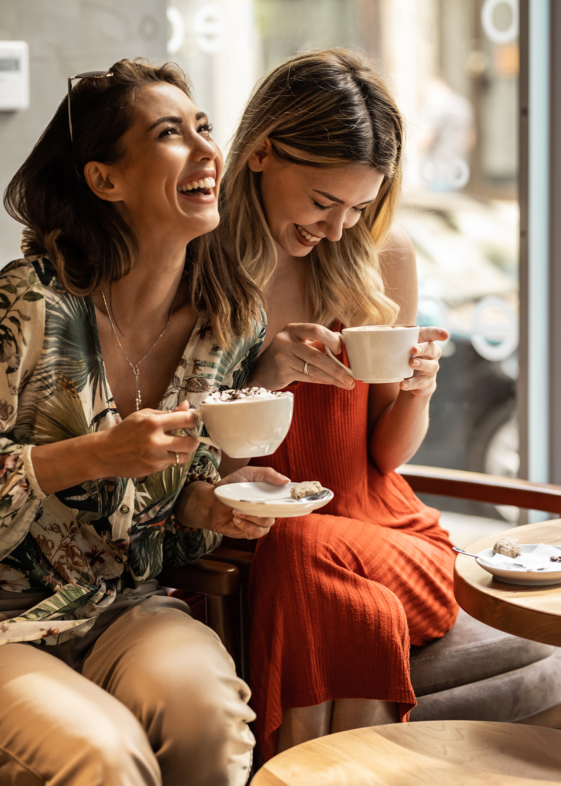 two women holding cups of coffee