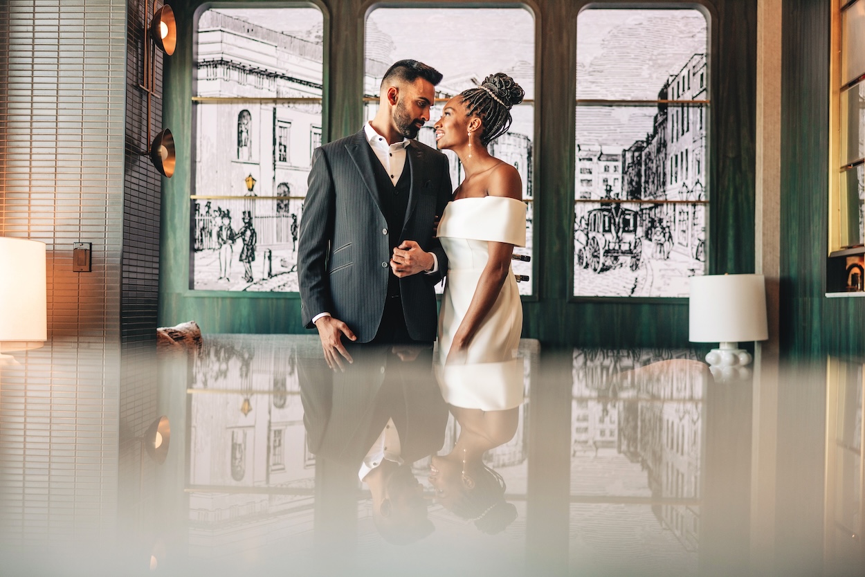 a man and woman standing in front of a window