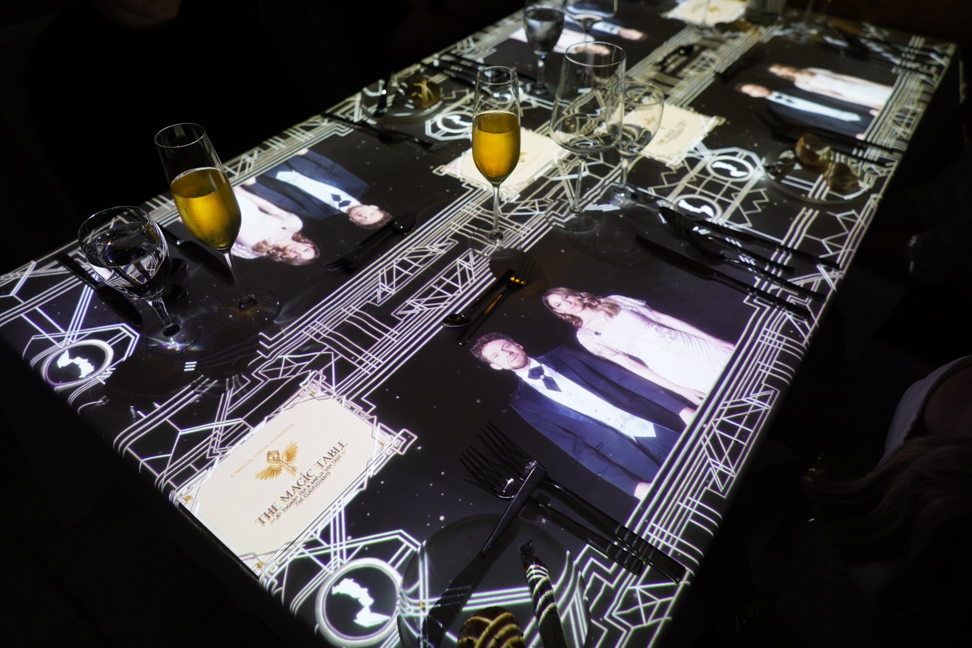 a table with glasses and a picture of a man and woman