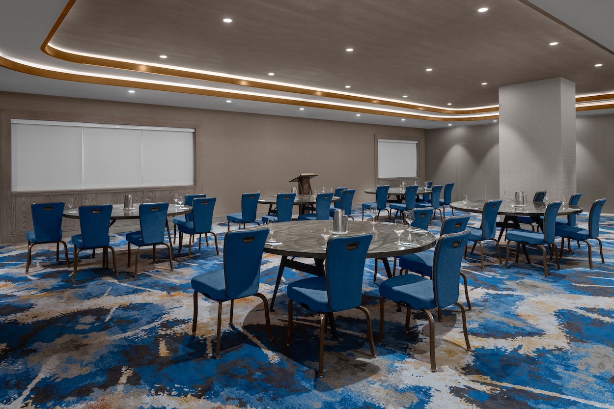 a room with a round table and blue chairs