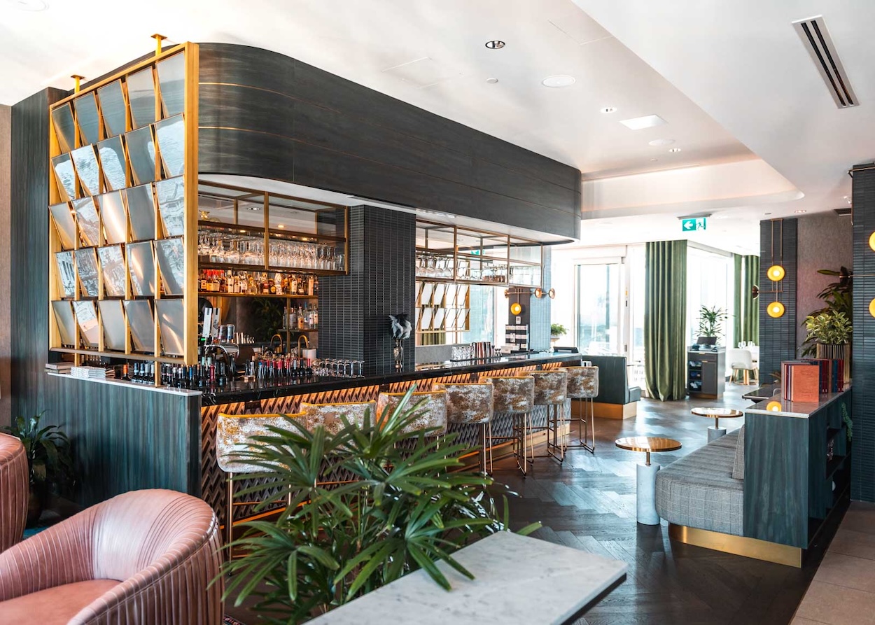 a bar with a counter and chairs in a room