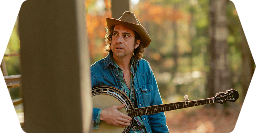 a man in a cowboy hat playing a banjo