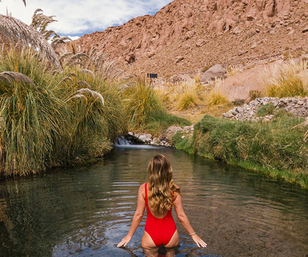 a woman in a red swimsuit in a river