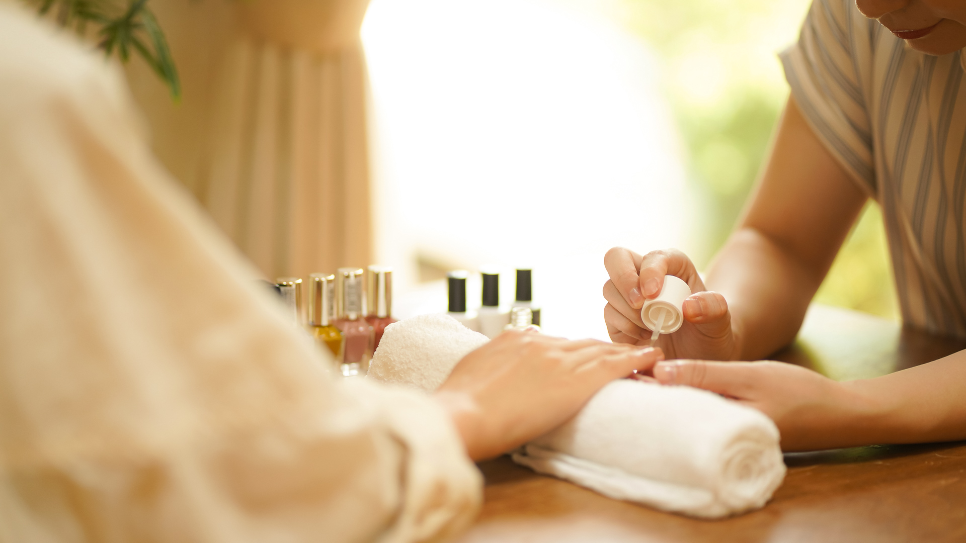 a woman applying nail polish on her hand