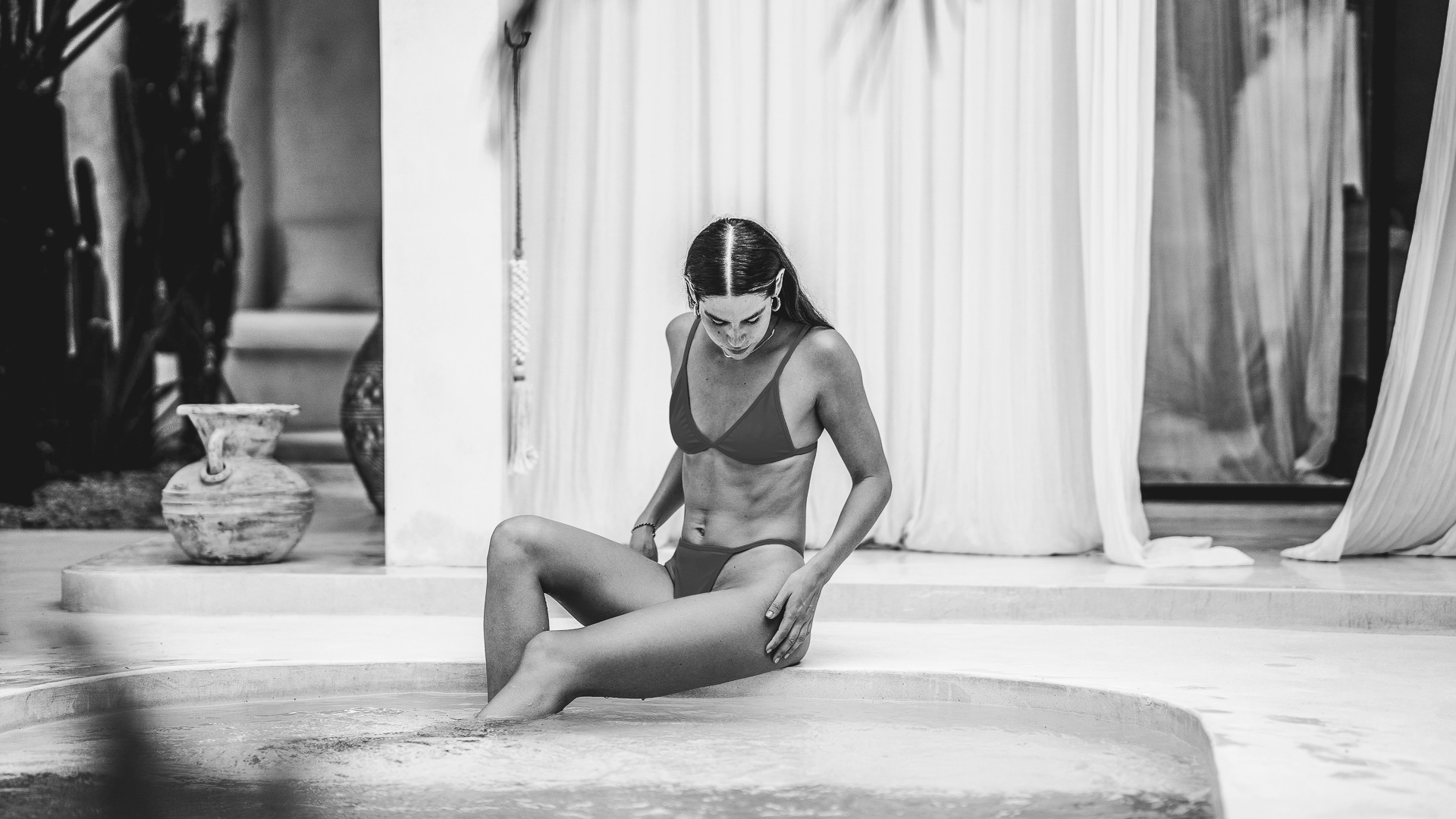 a woman in a garment sitting on a pool