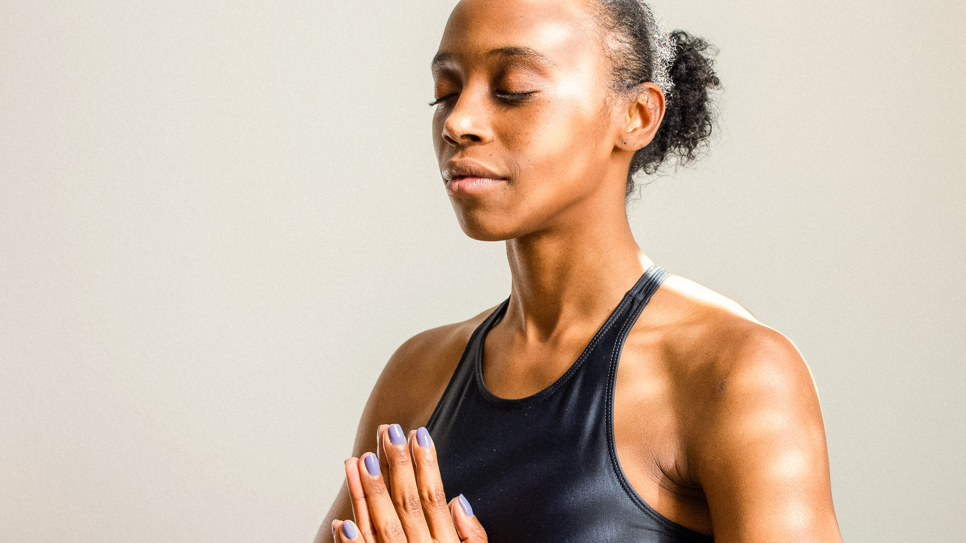a woman with her eyes closed and hands together in prayer
