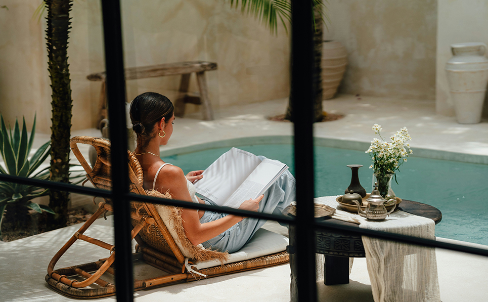 a woman sitting in a chair reading a book