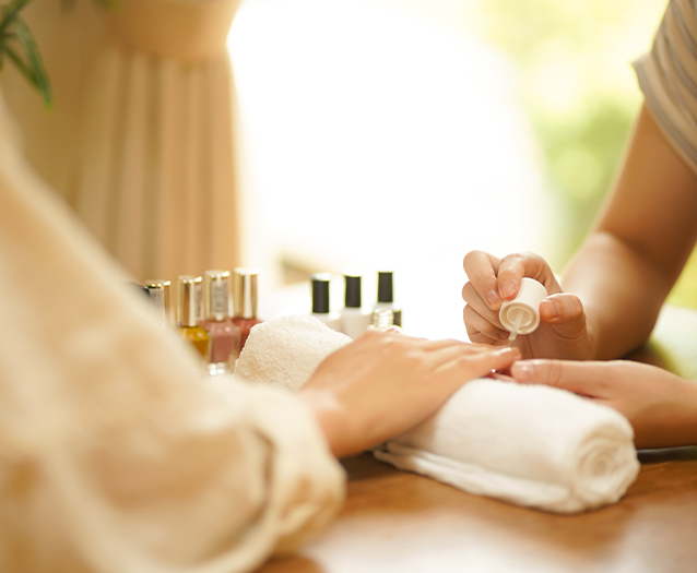a woman applying a nail polish on her hand
