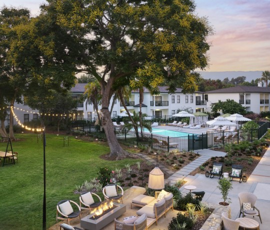 a pool and a patio with chairs and tables