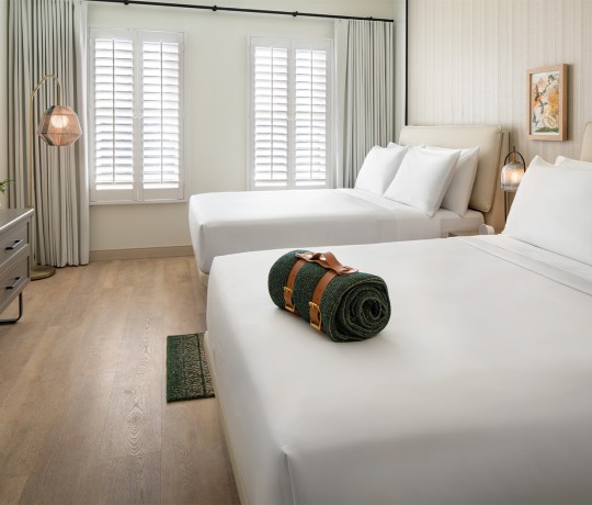 a bed with white sheets and pillows