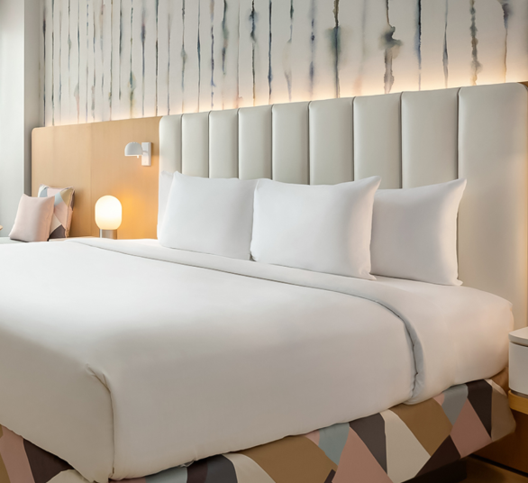 a bed with white sheets and pillows