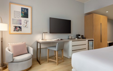 a room with a bed and a chair and a television