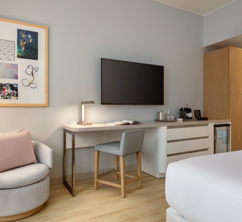 a room with a bed and a chair and a television