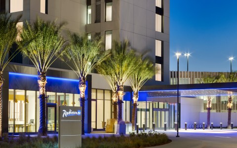 a building with palm trees and a sign