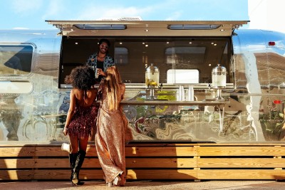a group of women standing in front of a food truck