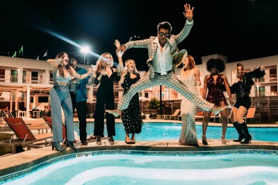 a group of people standing in the air by a pool