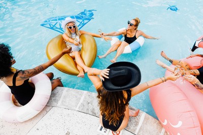 a group of women sitting in a pool with floaties