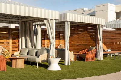 a patio with a striped canopy and chairs