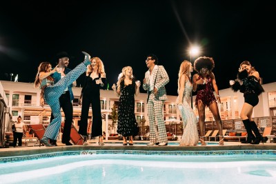 a group of people standing next to a pool
