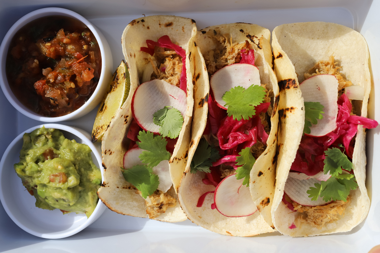 a plate of tacos with salsa and guacamole